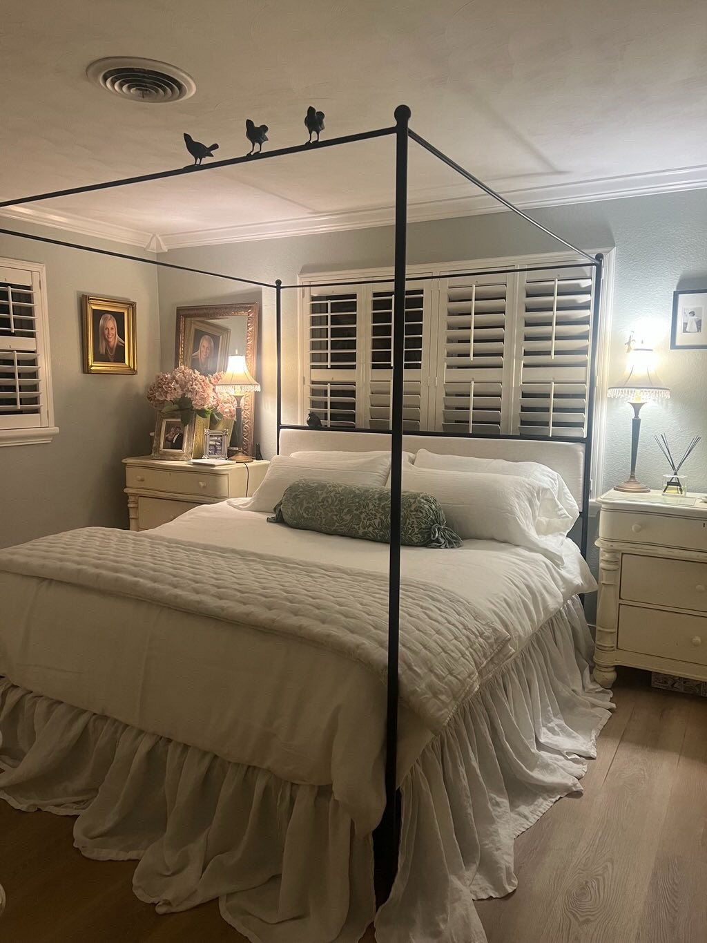 Bedroom with canopy bed, nightstands, and decorative elements.