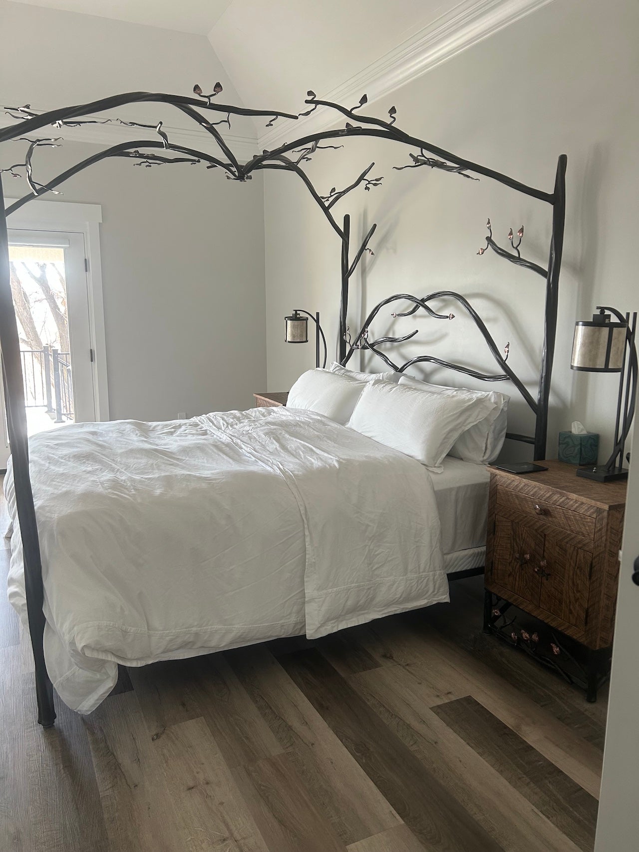 Bedroom with an Urban Forge Elm Springs canopy bed featuring a black metal frame and white bedding.