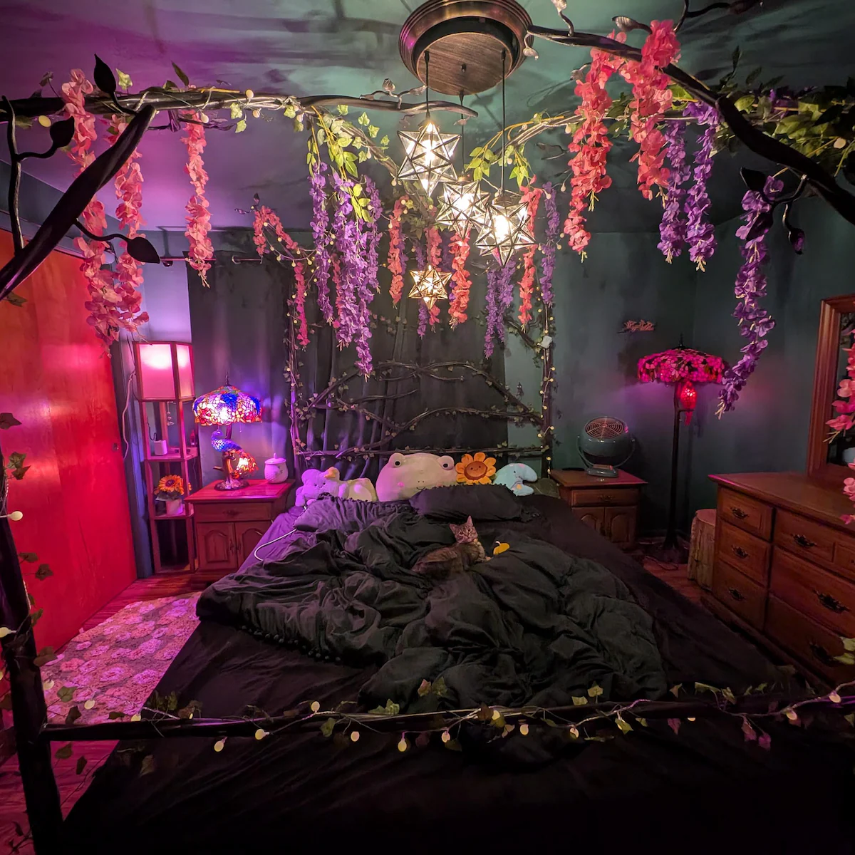 Decorative bedroom with floral arch, string lights, and colorful lighting.