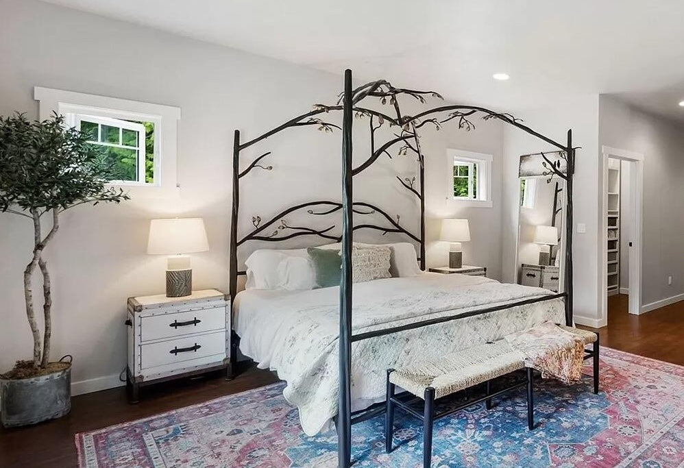 Bedroom with an Urban Forge Elm Springs canopy bed, nightstands, and a rug.