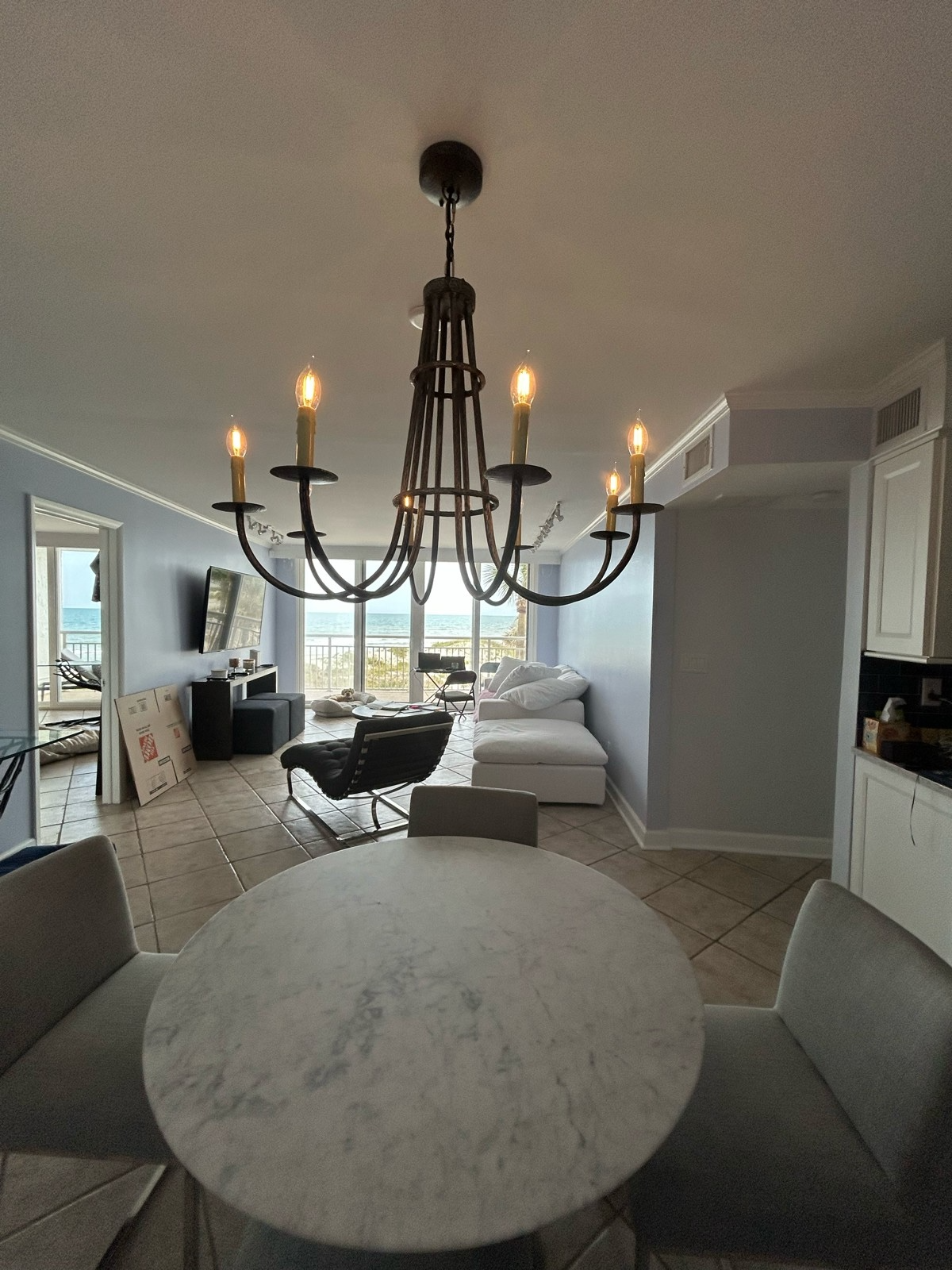 An Urban Forge Huntington chandelier hanging inside a beautiful beach house with an awesome view.