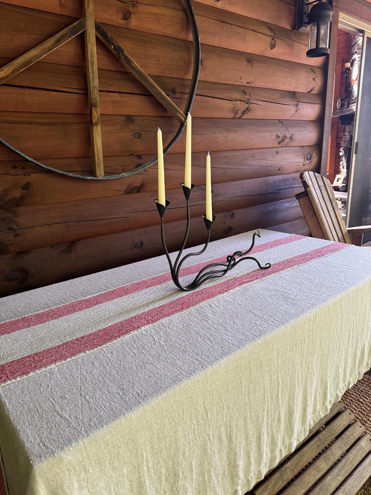 An Urban Forge Ivy triple candle holder resting in a cabin front porch.