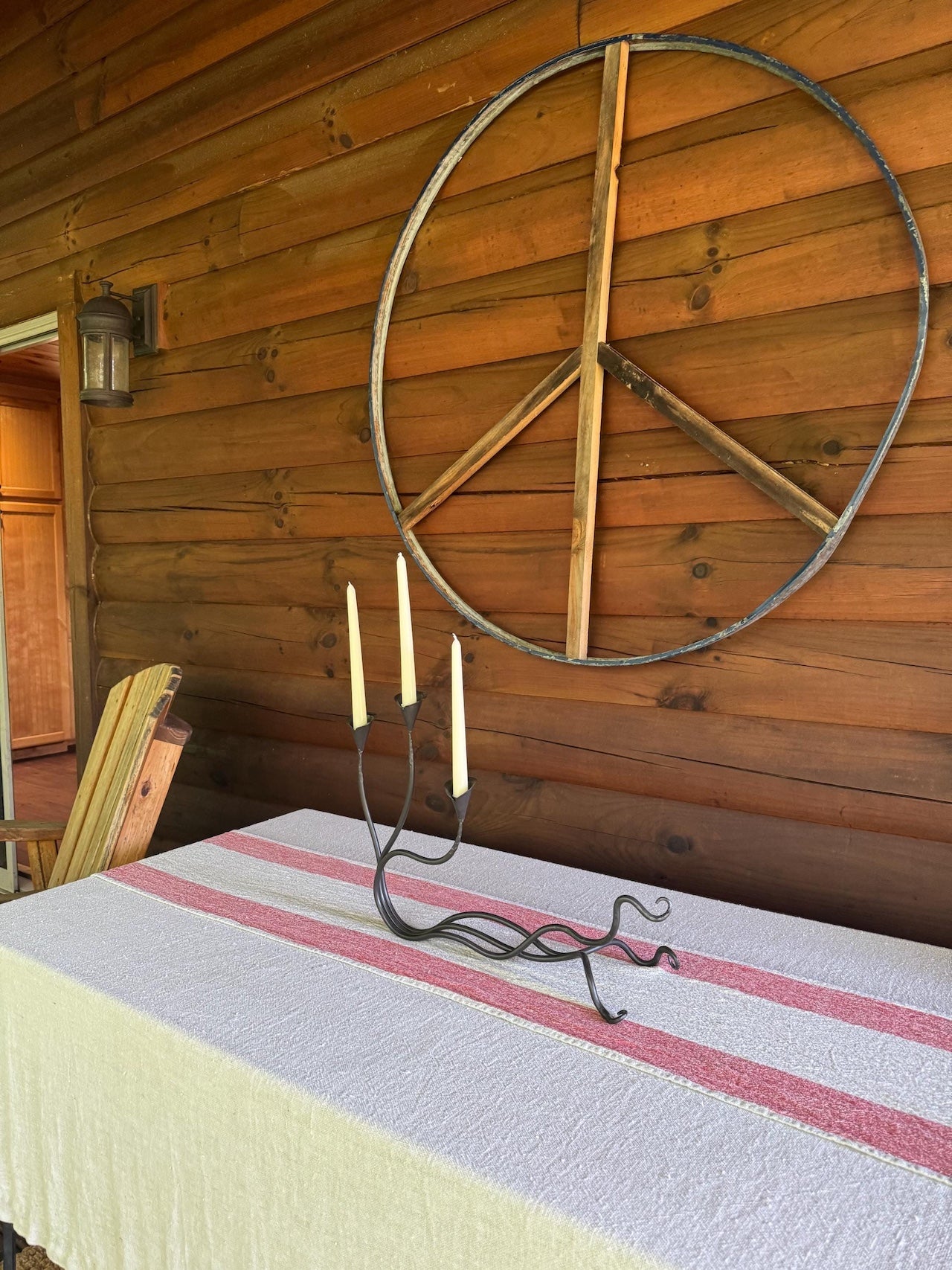 An Urban Forge Ivy triple candle holder resting in a cabin front porch.