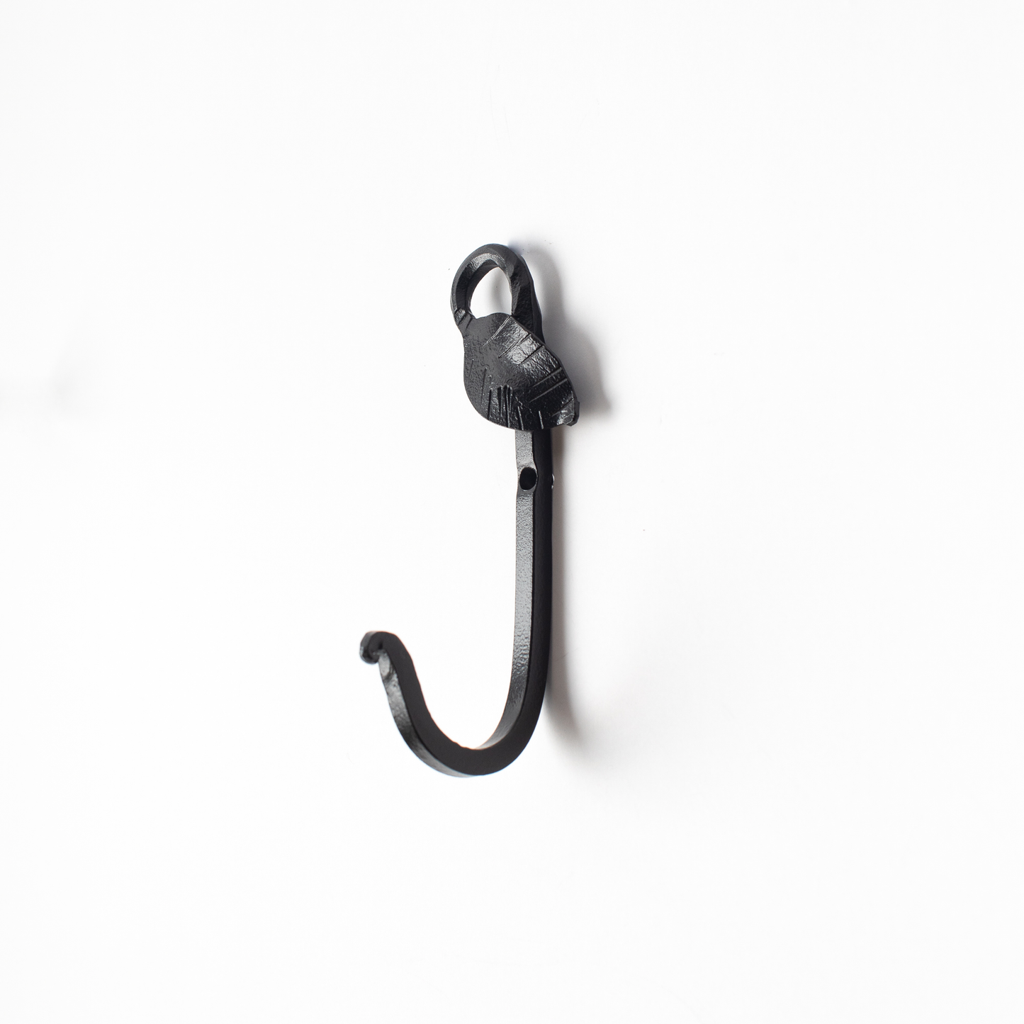 An Urban Forge Leaf hand-forged iron single hook in a black finish. The hook is pictured against a white backdrop.