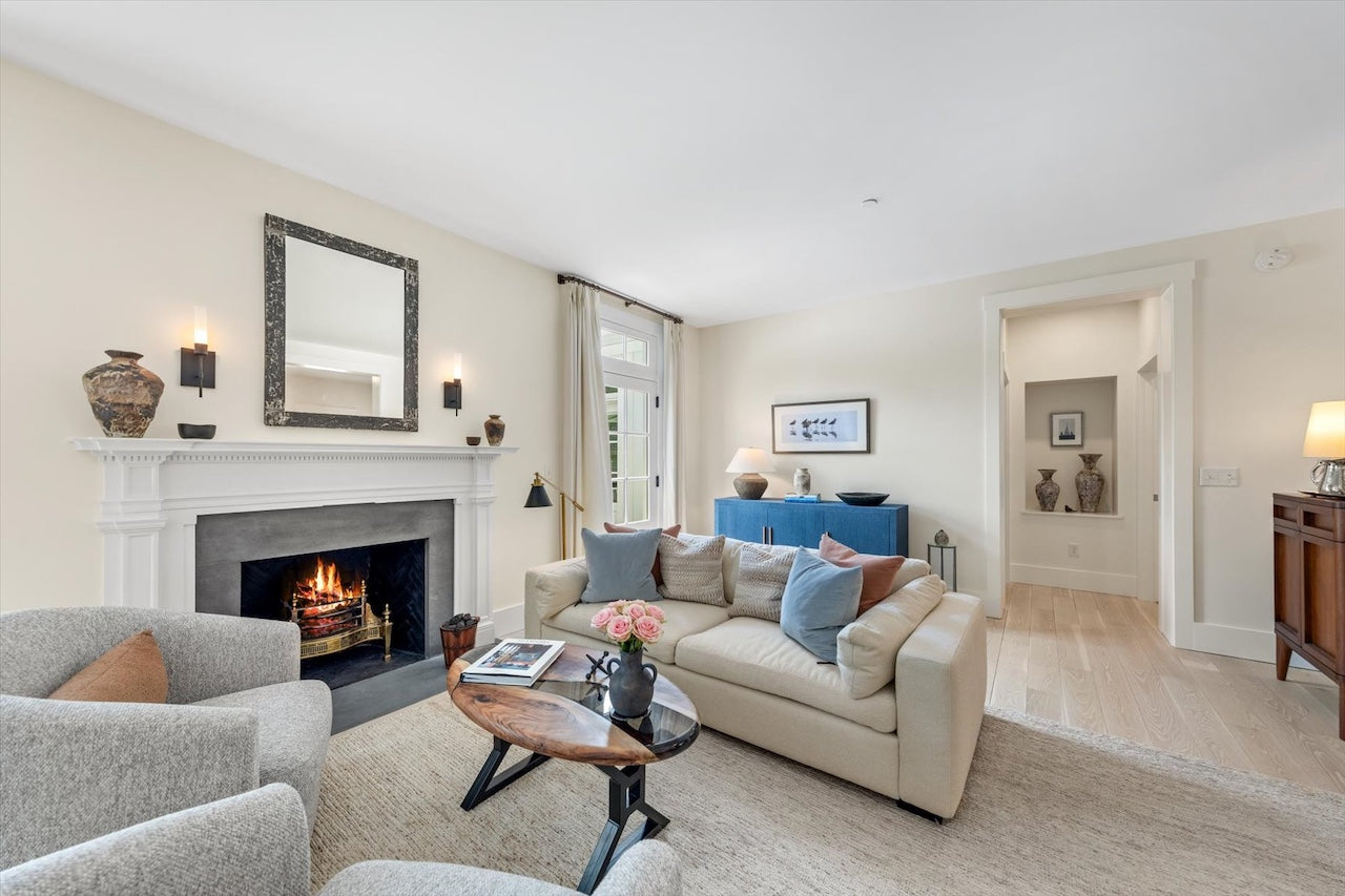 Living room with beige sofa, armchair, coffee table, and fireplace.