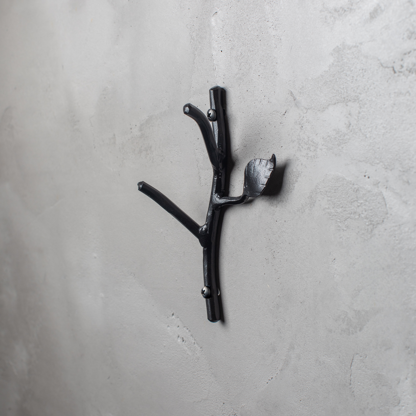 An Urban Forge Sylamore hand-forged iron double hook in a black finish. The hook is mounted on a gray wall.