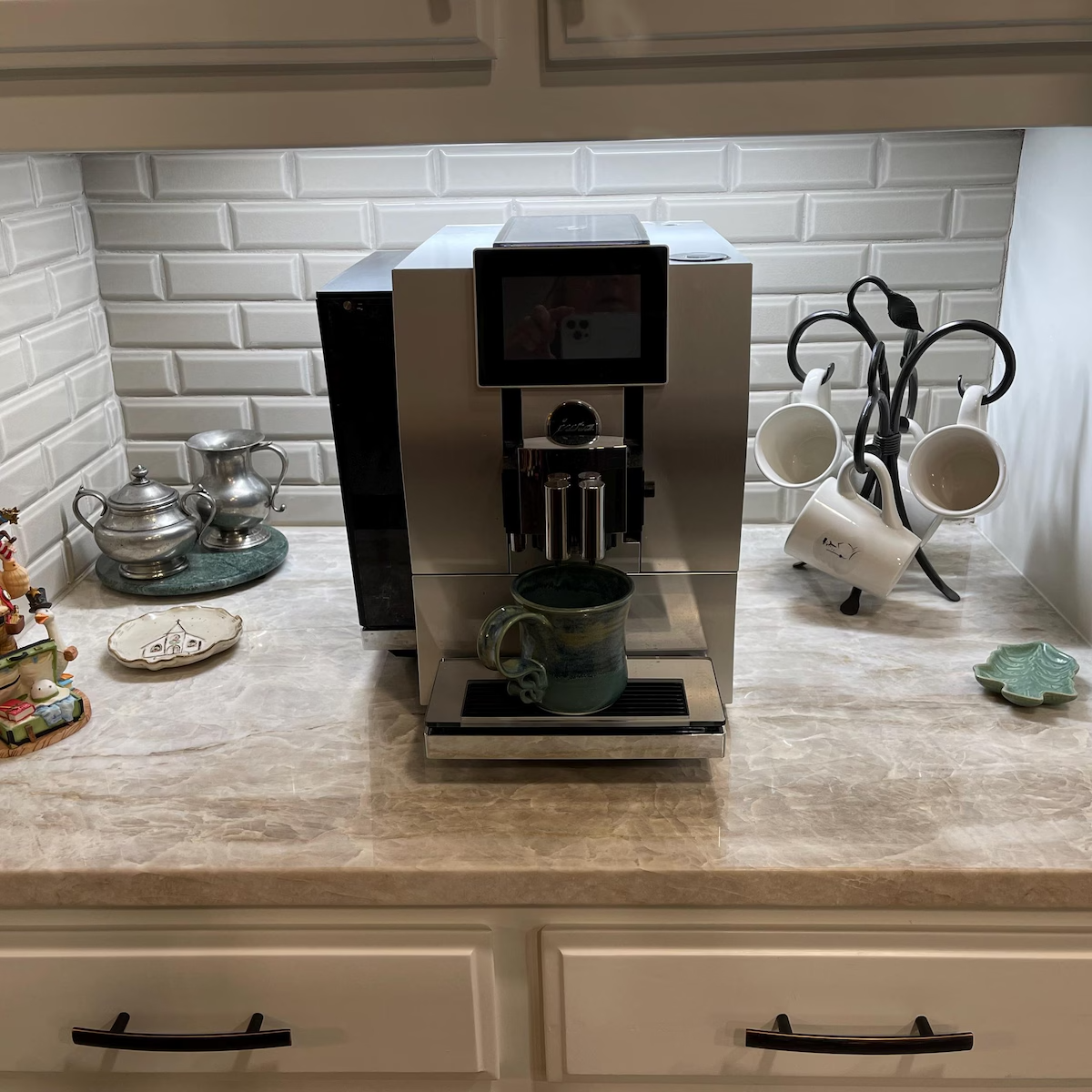 Coffee machine on a kitchen counter with decorative items in the background