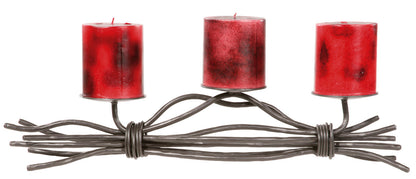The Urban Forge Black River triple candle holder in a black finish. The candle holder has three red candles and is pictured against a white backdrop.