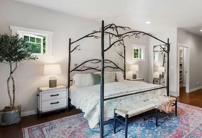Bedroom with an Urban Forge Elm Springs canopy bed, nightstands, and a rug.