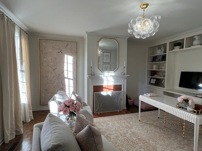 Two Urban Forge Ivy single candle holders are displayed on a hearth within a stunning home office decorated in white.