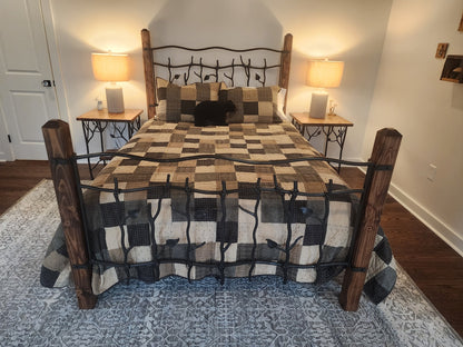Bedroom with a bed featuring a checkered quilt and wooden and iron headboard, two lamps on nightstands.