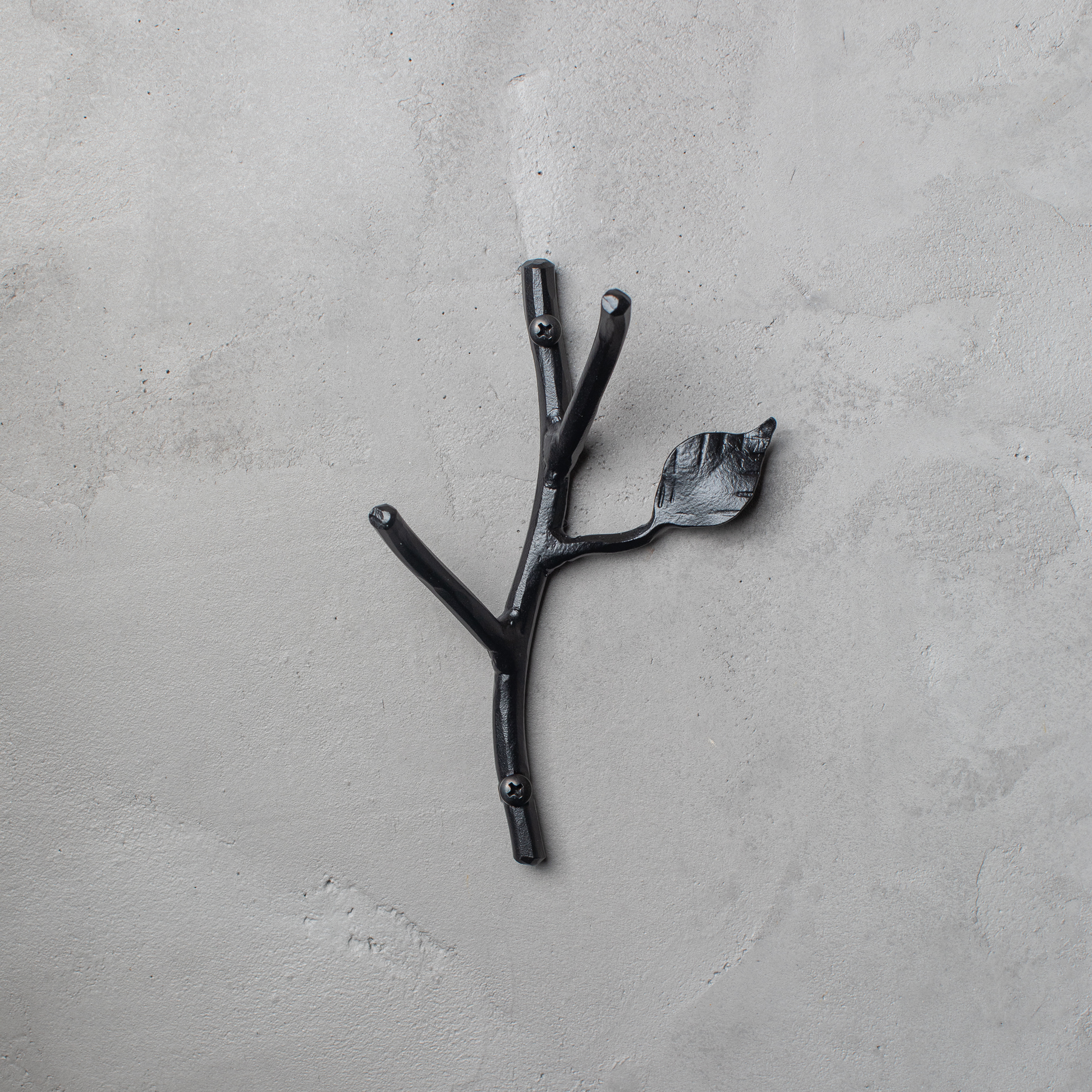 An Urban Forge Sylamore hand-forged iron double hook in a black finish. The hook is mounted on a gray wall.