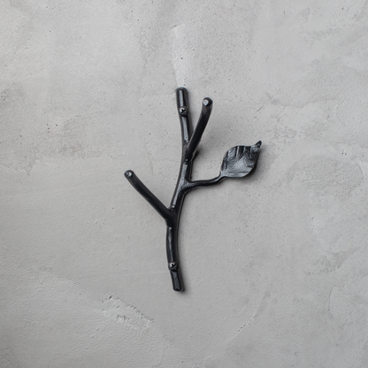 An Urban Forge Sylamore hand-forged iron double hook in a black finish. The hook is mounted on a gray wall.