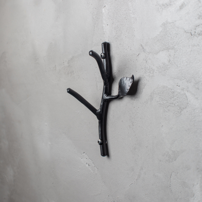 An Urban Forge Sylamore hand-forged iron double hook in a black finish. The hook is mounted on a gray wall.