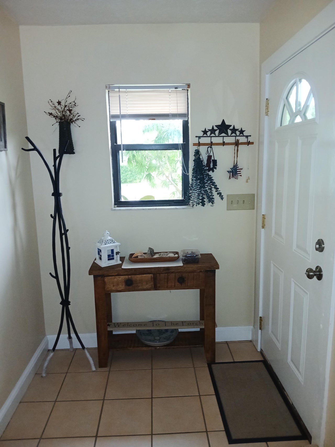 A home entry features an Urban Forge Sylamore standing coat rack in a black finish.