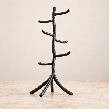 Twig hand-forged mug tree in Coal Black, upright with six unobstructed hooks on a light stone surface.